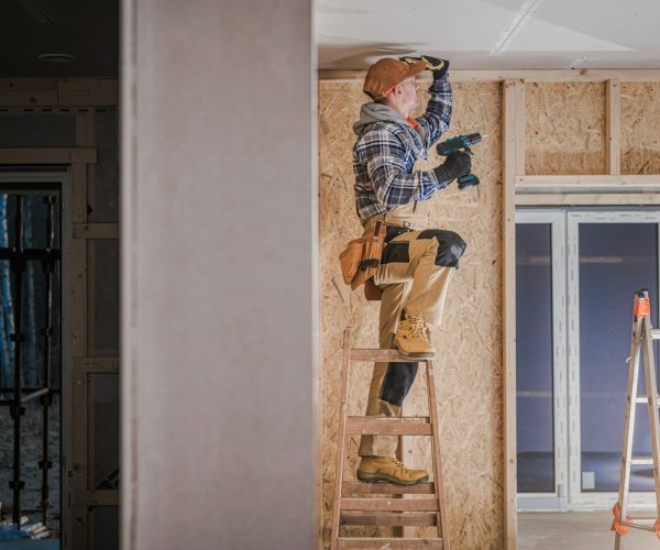 Construction Worker Installing Drywall Ceiling Elements