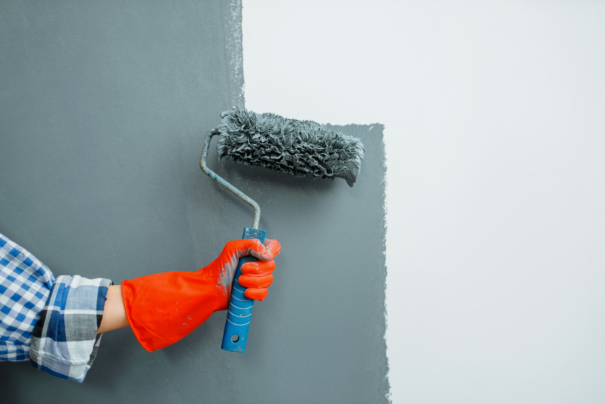 Female house painter hand with paint roller